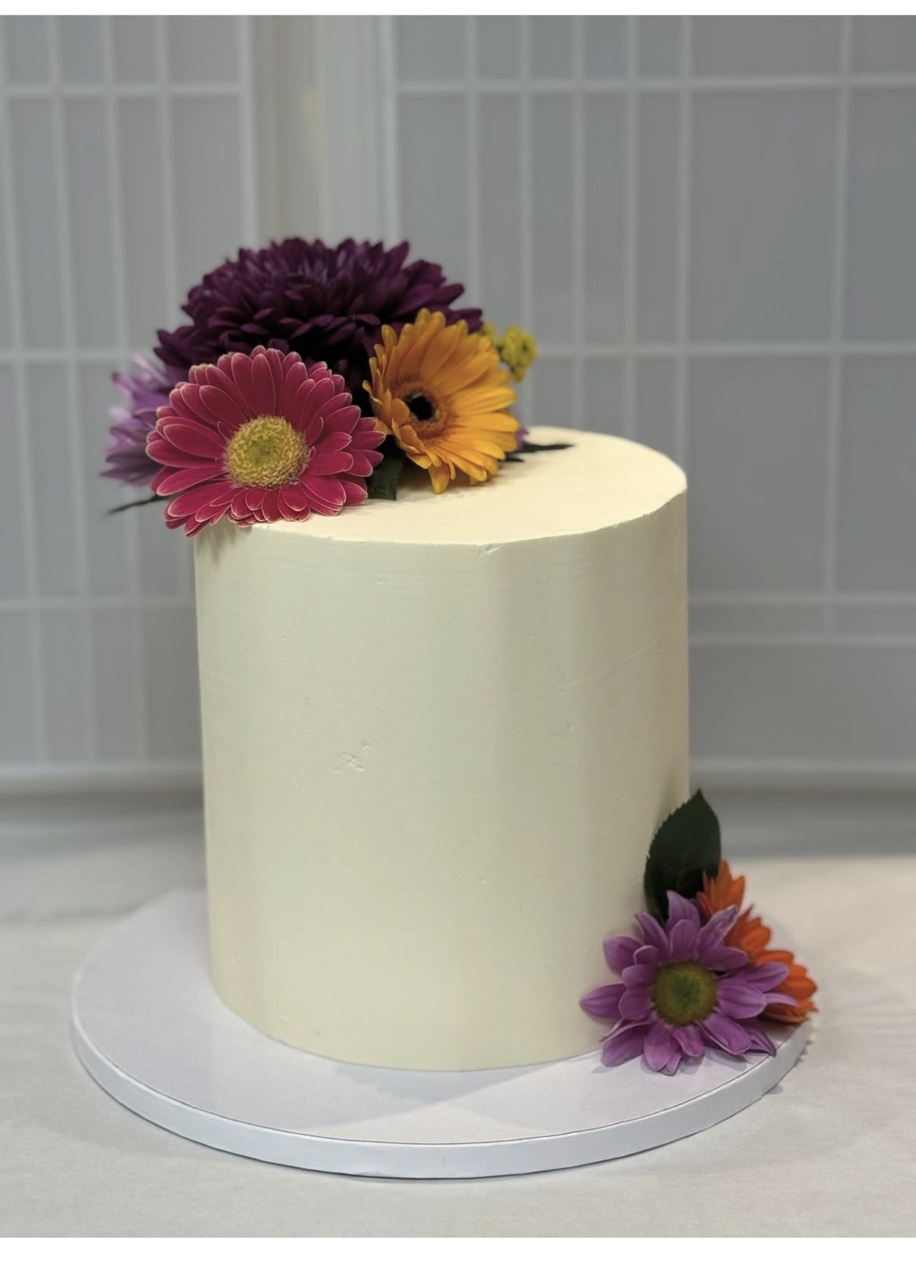 Layer cake ivoire décoré de fleurs fraîches, une création du Comptoir des Délices