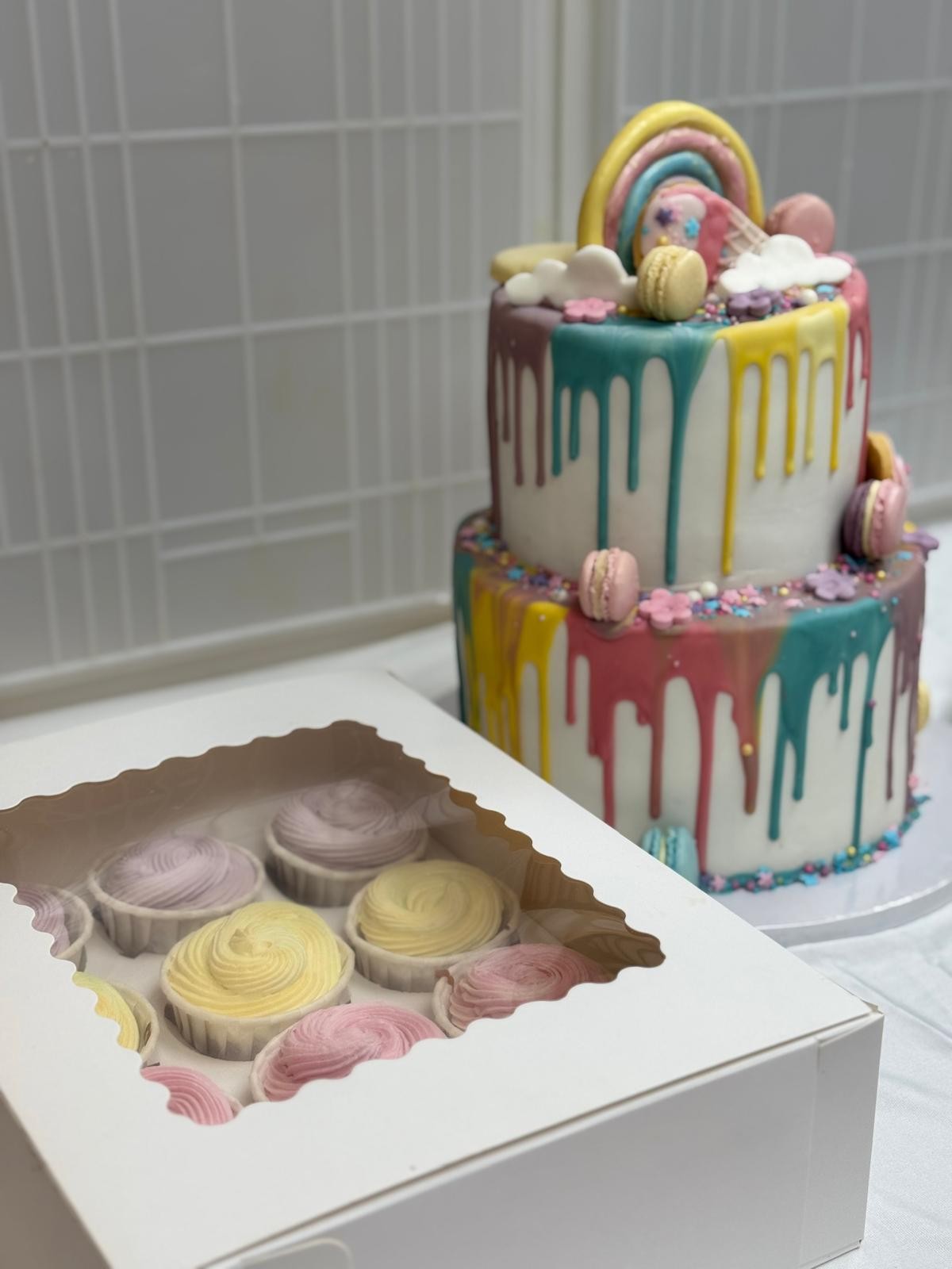 Drip cake arc-en-ciel avec cupcakes assortis