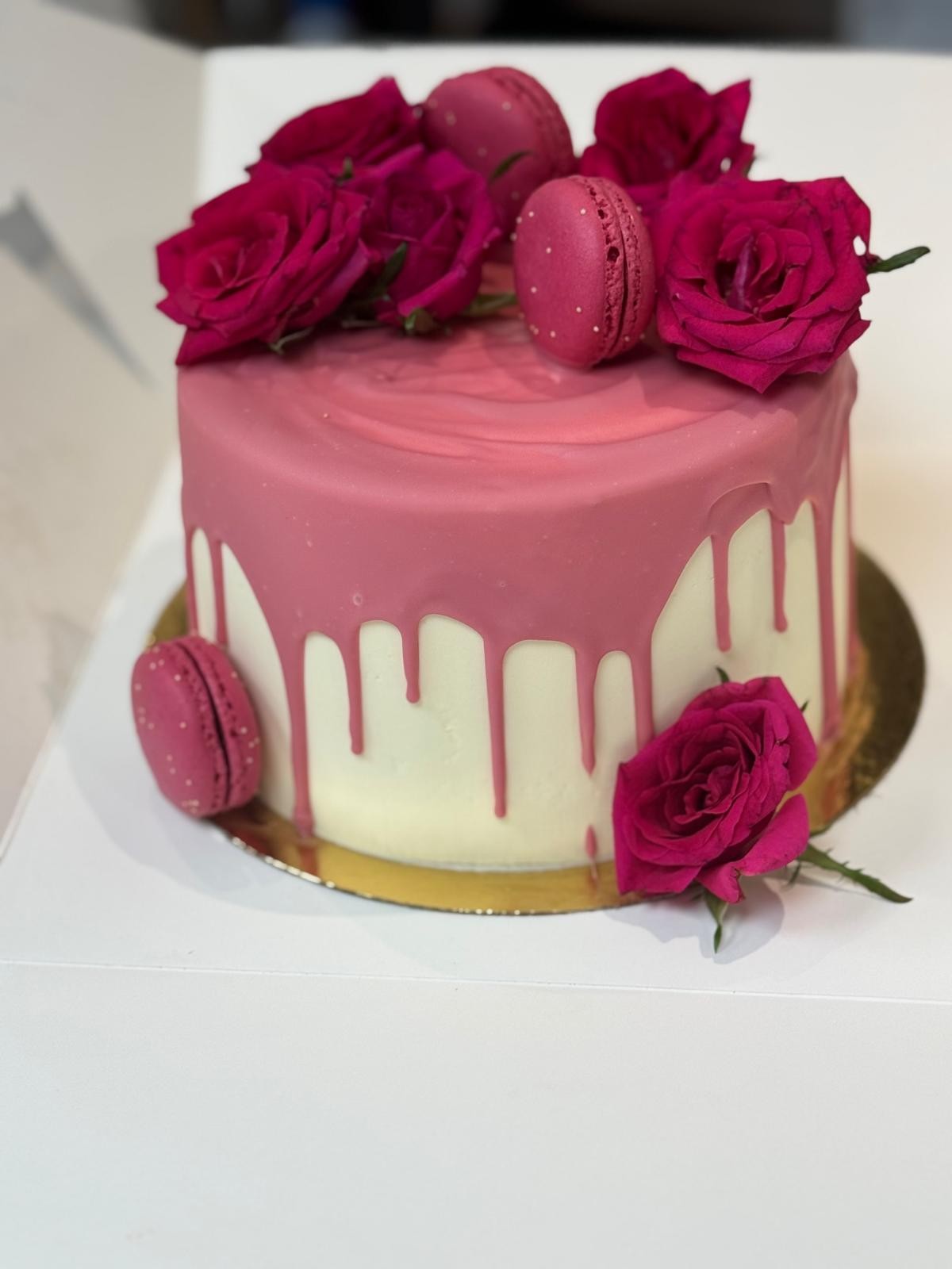 Drip cake rose décoré de roses fraîches et macarons