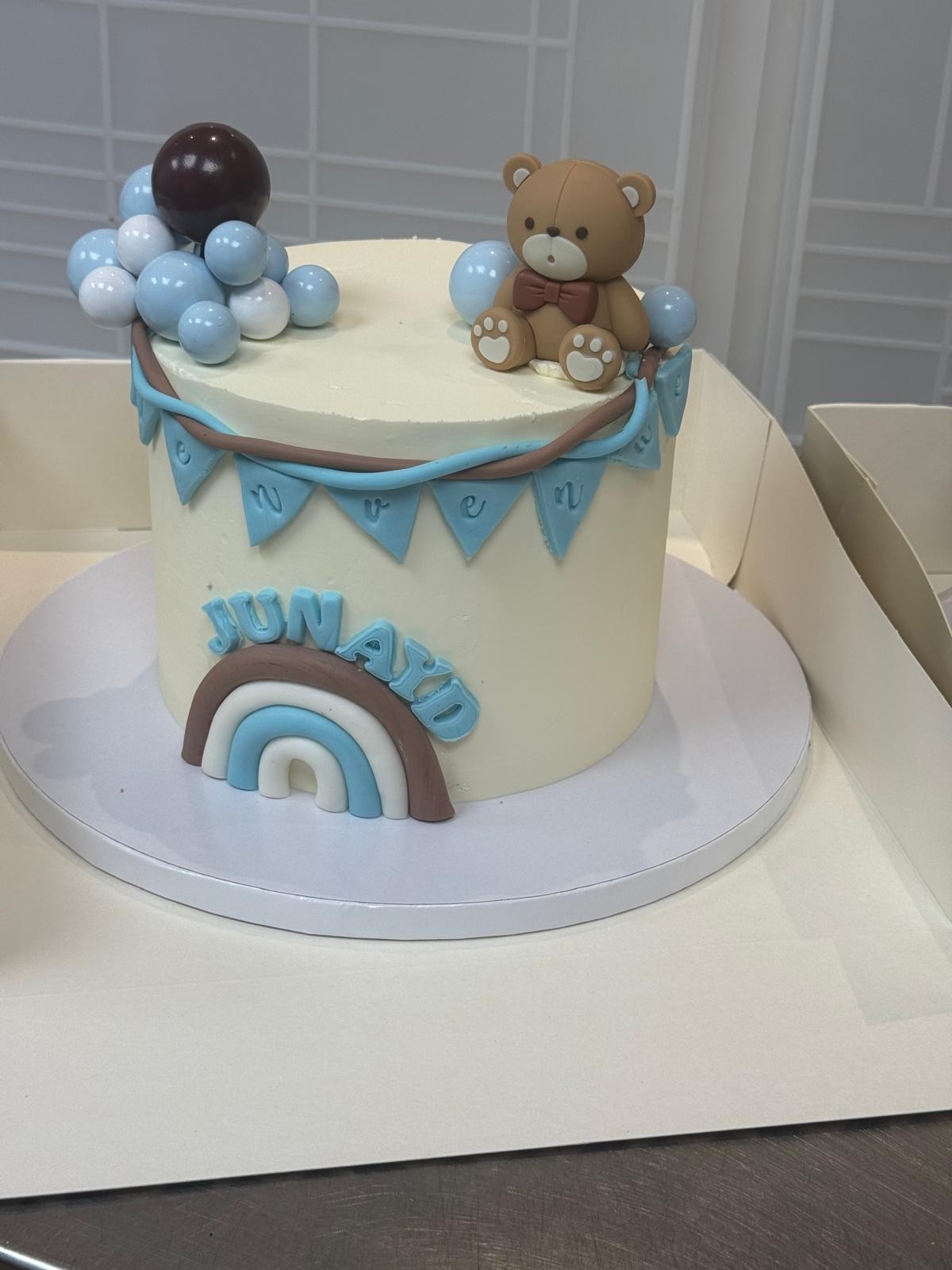 Gâteau de naissance bleu avec ballons et ourson