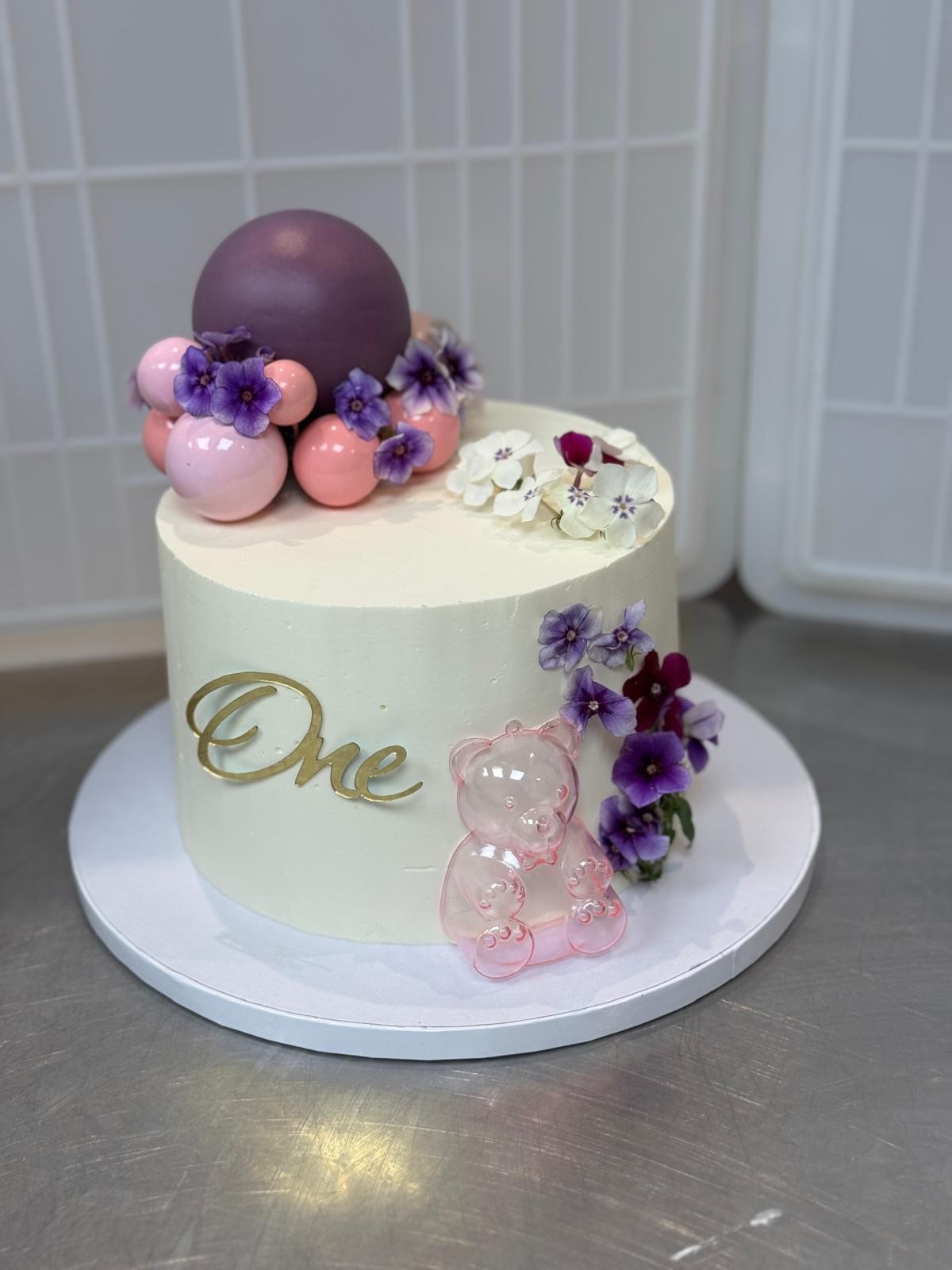 Gâteau '1 an' décoré de fleurs et sphères